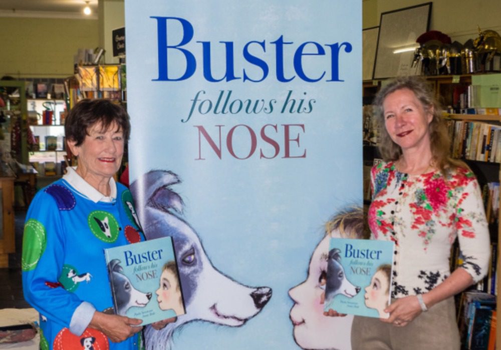 Author Paula Stevenson and illustrator Penny Hale holding a copy of ‘Buster Follows His Nose’ picture book.